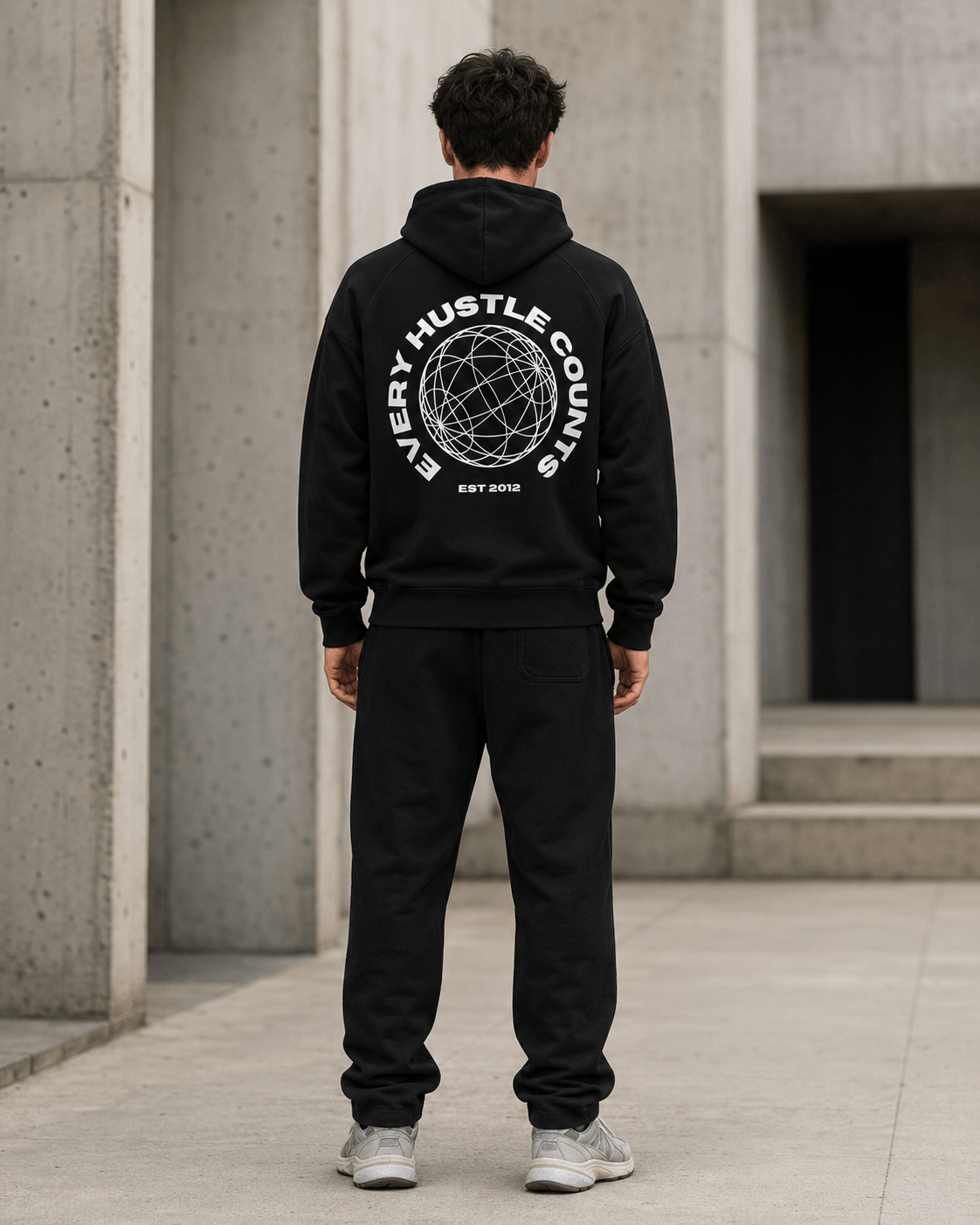 Model wearing the Every Hustle Counts EHC World black hoodie, back view showing globe print