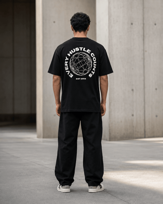 Model wearing the Every Hustle Counts EHC World black t-shirt, back view showing globe print