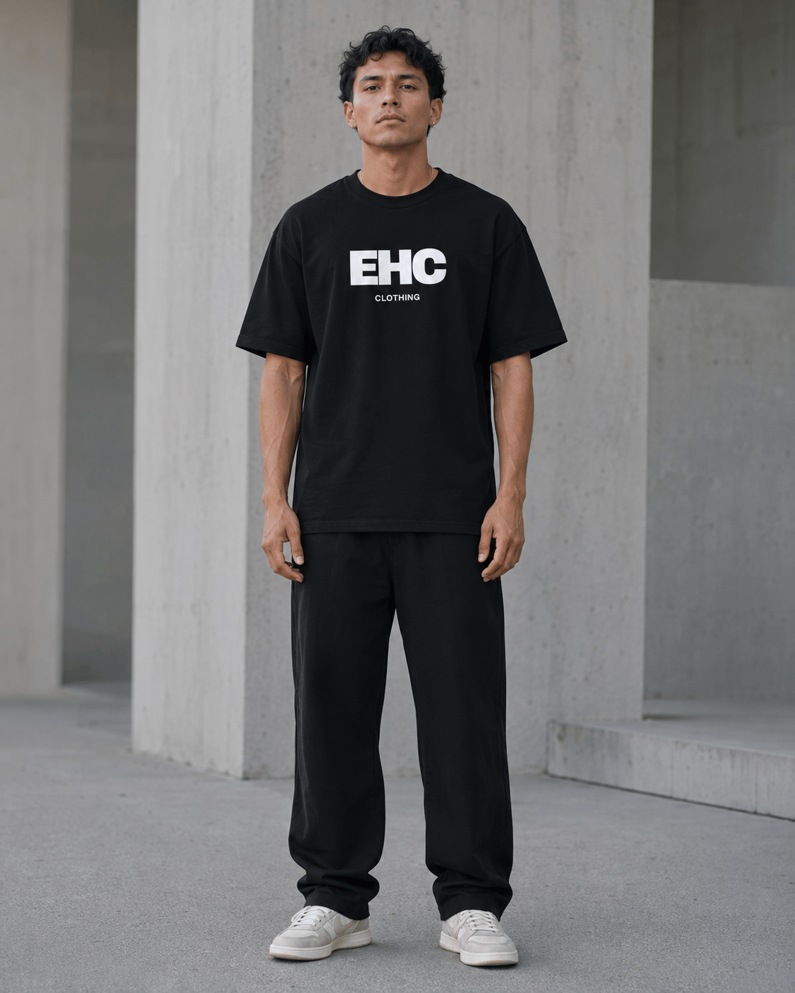 Model wearing the Every Hustle Counts EHC World black t-shirt and black trousers, front view