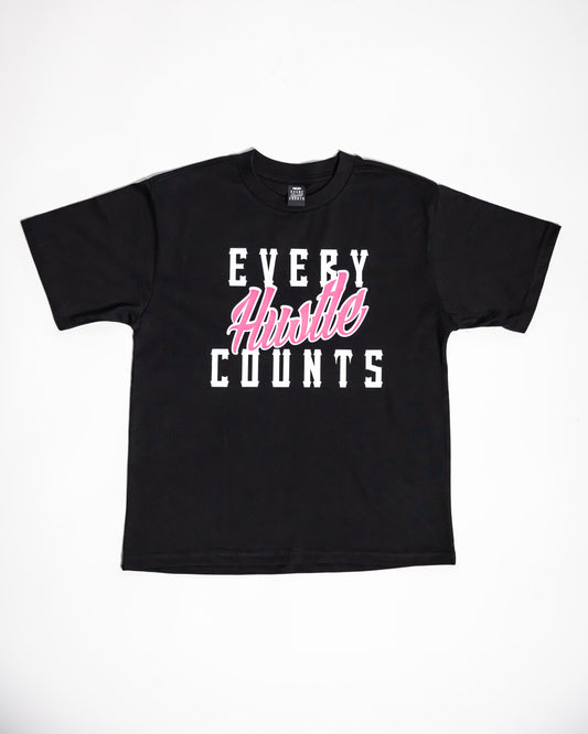 Every Hustle Counts black kids t-shirt with pink script chest print, flat lay